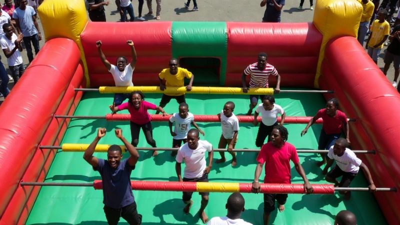 Players competing on a life-size human foosball court